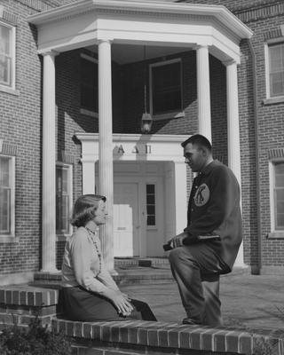 An unidentified woman in talking to an unidentified man in front of the Alpha Delta Pi House