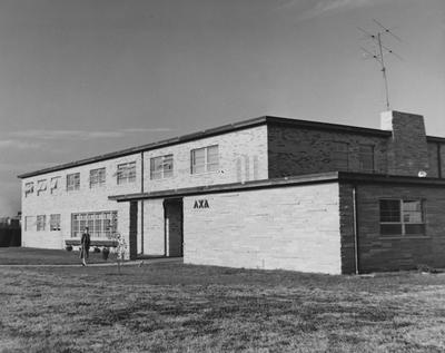 An unidentified woman is standing in front of the Lambda Chi Alpha house