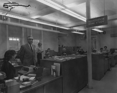 Unidentified people are working in the Home Study registration area, now called Independent Study, located in Frazee Hall. Frazee Hall was built in 1907 and named after David Frances Frazee on June 3, 1931. On January 24, 1956, the building was partially destroyed by a fire