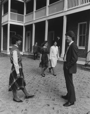 Large porches open off a rear wall of the conference center onto a brick patio. Enjoying the warm spring air are, from the left: Regina Wink (foreground), Dr. William Adams, Lisa M. Rohleder, Fran Steward (both walking), Charles Ison (on the porch) and Chris Pramuk (foreground)