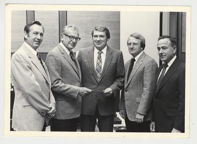 Three unidentified men and Robert Congleton (far right) are presenting a check to President Otis Singletary (second from the left)