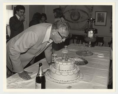 President Singletary is blowing out candles at his surprise birthday party thrown by the Mortar Board