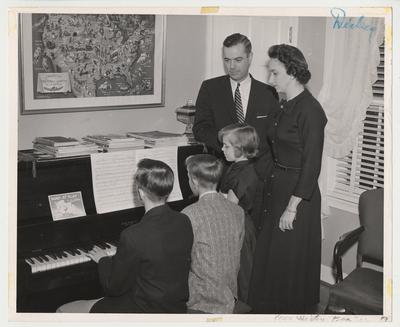 From the left:  Frank Dickey Jr., Joe, Ann, President Dickey, Betty (wife).  The family is gathered around a piano