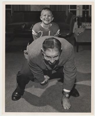 President Oswald and his son Johnny Oswald Jr. are indoors playing football
