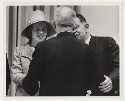 Rosanel (right) and President Oswald (left) greet an unidentified man in a reception line