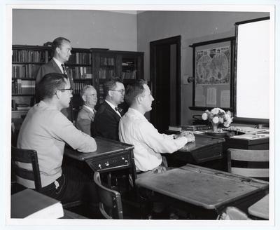 Five unidentified men in Miss Shipman's Rapid Reading class, part of the University Extension Program.  University Extension was the forerunner to distance learning