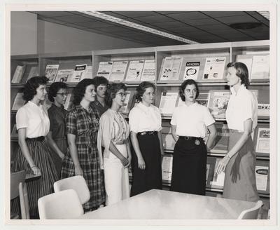 Miss Suzanne Prough, Assistant Professor of Nursing, explains the various periodical publications concerned with the nursing profession to members of the College of Nursing class.  Listening are, from the left, Donna Hall, Margaret Hoskins (College of Nursing receptionist), Louise Bargo, Ann Combs, Linda Enslen, Elaine Kiviniemi, and Martha McLallen