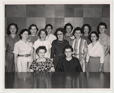 Dr. Judith Pratt, Associate Professor of Nursing (standing middle row, far right); Virginia Lane, Associate Professor of Nursing (standing back row, second from right); Dean Marcia Dake, Dean of the College of Nursing (seated right); and ten unidentified women