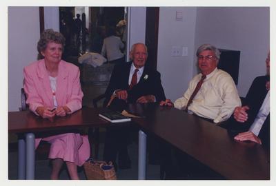 Jerry Crouch (far right), Robert Sexton (second from right), Dr. Thomas D. Clark (center), and Nancy Baird (far left) are seated around a table and Dr. Thomas D. Clark's 100th birthday celebration at Young Library