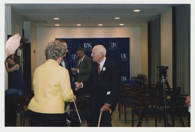Thomas D. Clark (right) is talking with President Lee Todd (second from left) and Patricia B. Todd at his 100th birthday celebration at Young Library.  Carl Nathe is standing (center) near Thomas Clark
