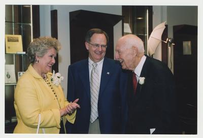 Thomas D. Clark is talking with President Lee Todd (center) and Patricia B. Todd (left) at his 100th birthday celebration at Young Library