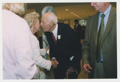 Thomas D. Clark (center) is shaking hands with Isabel Yates, Uban County Council (right), while William J. Marshall, Director of Special Collections and Archives (right) watches at Dr. Thomas D. Clark's 100th birthday celebration at Young Library