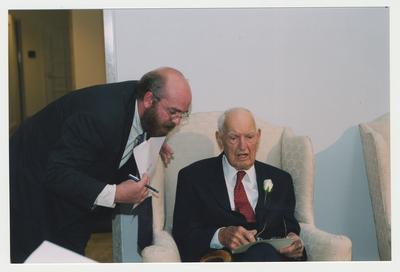 Stephen Winn (left) is talking with Dr. Thomas D. Clark (right) at Dr. Thomas D. Clark's 100th birthday celebration at Young Library