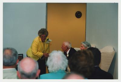 Patricia Todd (left) is shaking Thomas Clark's (center) hand, while Loretta Brock (right) and unidentified men and women watch at Dr. Thomas D. Clark's 100th birthday celebration at Young Library