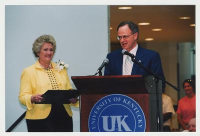 Patricia Todd (left) is listening to President Lee Todd speak at Dr. Thomas D. Clark's 100th birthday celebration at Young Library.  Thomas D. Clark is visible in the bottom right corner