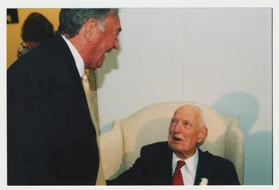 Former Governor Louie B. Nunn (left) is talking with Thomas Clark (right) at Dr. Thomas D. Clark's 100th birthday celebration at Young Library