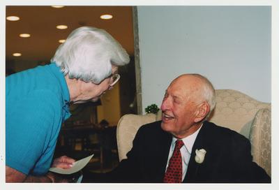 Betty Rosenthal (left) is talking with Thomas Clark (right) at Dr. Thomas D. Clark's 100th birthday celebration at Young Library