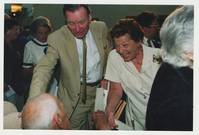 Foster Ockerman (left)and Mrs. Ockerman (right) are talking with Thomas Clark (seated, left) at Dr. Thomas D. Clark's 100th birthday celebration at Young Library
