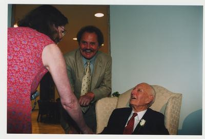 James Archambeau (center) and an unidentified woman (left) are talking with Thomas Clark at Dr. Thomas D. Clark's 100th birthday celebration at Young Library