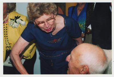 Sarah Henry (left), Professor of Home Economics, is talking to and shaking hands with Thomas Clark (right)at Dr. Thomas D. Clark's 100th birthday celebration at Young Library