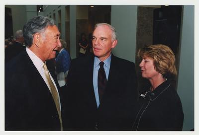 Carol Diedrichs (right), Dean of Libraries, is talking with UK Provost Mike Nietzel (center) and Former Governor of Kentucky Louie B. Nunn (left) at Dr. Thomas D. Clark's 100th birthday celebration at Young Library