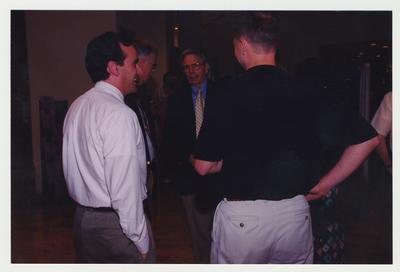 Ken Williams (far left), Editor Register of the Kentucky Historical Society, Charles Hay (left of Ken Williams), George Herring (center), UK History Professor, and an unidentified man are talking at Dr. Thomas D. Clark's 100th birthday celebration at Young Library