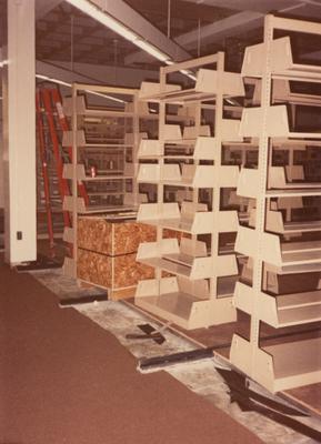 A color photo of an unidentified person building shelves for periodicals and serials on the second floor of Margaret I. King North Library. Photographer: Terry Warth