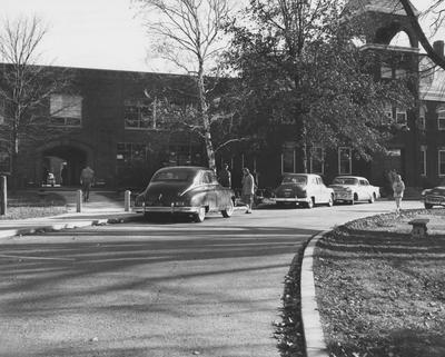 Students walking by and cars parked in front of Anderson Hall. Received November 27, 1957 from Public Relations