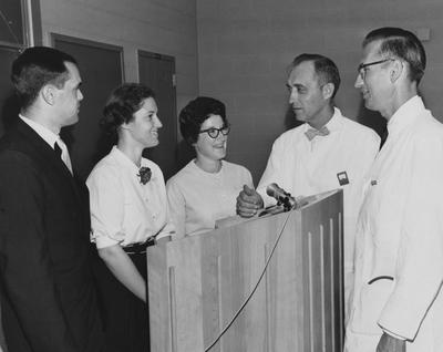 Various unidentified people are gathered around a podium; second woman on the right is R. Eubank. Herald-Leader Photograph
