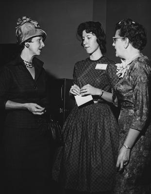 Three unidentified women are conversing at the dedication of the Medical Center