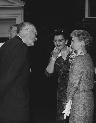 Two unidentified men and two unidentified women are conversing at the dedication of the Medical Center