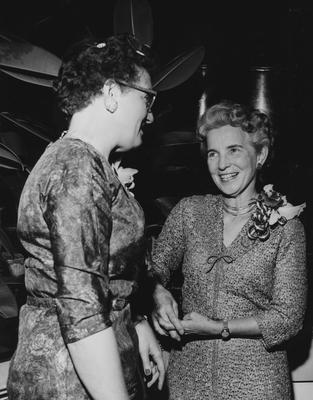 Two unidentified women are conversing at the dedication of the Medical Center