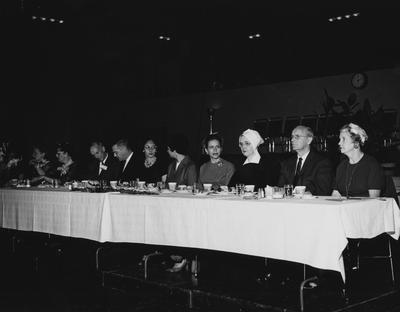 Unidentified people are sitting at a table at the dedication of the Medical Center