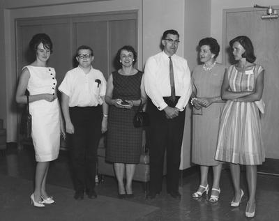 M. A. Dake (second from right) is standing in a room with unidentified people at the dedication of the Medical Center