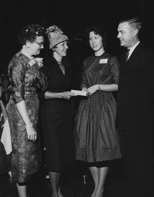 Three women and President Dickey are conversing at the dedication of the Medical Center