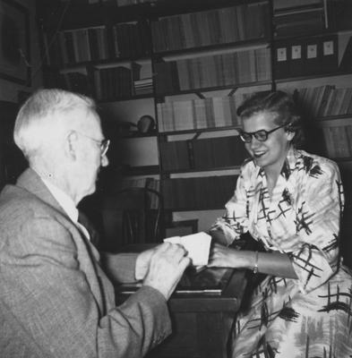 Ezra Gillis and Mrs. Winifred Lewellen look over first requests for reserved seats for the dedication of Memorial Coliseum