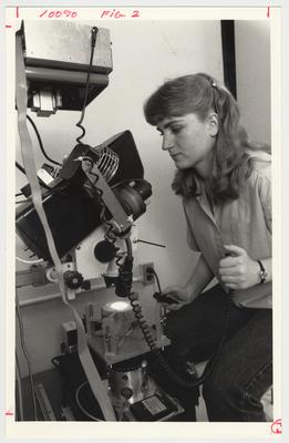 An unidentified woman is using a piece of equipment