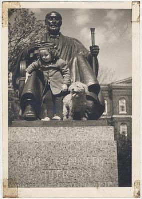 An unidentified little girl and her dog are standing on the Patterson Statue