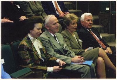 A row of people seated in an auditorium.  From the left:  The Princess Royal Anne of Great Britain; Peter Timoney, director of the Gluck Equine Research Center; Alice Chandler; and an unidentified man