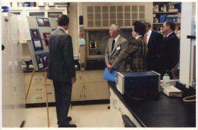 An unidentified man is giving a presentation in a laboratory in the Gluck Equine Research Center.  From the left:  an unidentified man; Peter Timoney, director of the Gluck Equine Research Center; an unidentified man; the Princess Royal Anne of Great Britain; and UK President Lee Todd