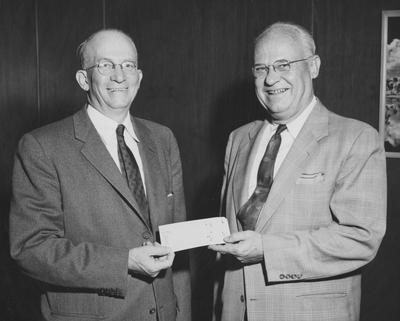 Frank D. Peterson (left) accepts a check for two million dollars for Housing Shawneetown or dorm from Walter E. Royes (right)- Regional Director of Federal Housing Administration, Atlanta. Received March 14, 1957 from Public Relations