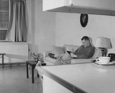 Ben Johnson reading in his living room at Shawneetown. Received March 21, 1958 from Public Relations