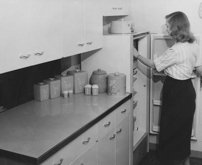 Ben Johnson's wife at the refrigerator at Shawneetown. Received March 21, 1958 from Public Relations