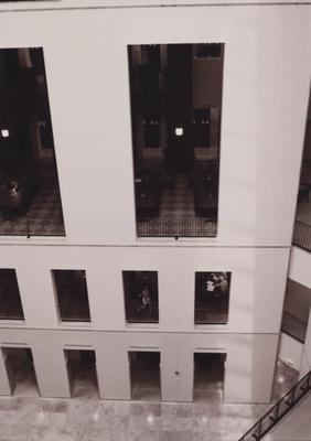 A sepia tone photo taken from the fifth floor looking down showing the first, second, and third floors and the stairs leading up to the second floor. This photo was taken before it's dedication in 1998. This photo was donated to UARP on May 1, 2003 by Teresa Burgett, Reference Librarian at Young Library