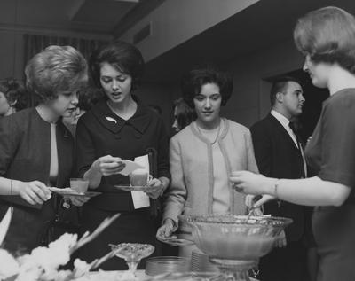 President John Oswald's reception for the junior class, held in the Alumni House. Four junior women at the tea table; third from left is Cheryl Benedict of Irvine, Kentucky. Photo appeared on page three in the February 27, 1964 issue of the Kentucky Kernel