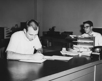Two unidentified men in an office. Received November 2, 1964 from Public Relations