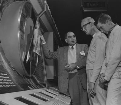 Ancel E. Cook (left), Wayne Baxter (center), Freddy Vanny (right) are talking at a display at a career carnival. Photographer: Herald-Leader. Received November 4, 1958 from Public Relations