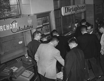 Men looking at Dictaphones and Merchant calculators at the 1960 Career Carnival. Received November 1, 1960 from Public Relations