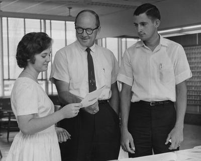 One woman showing a brochure to two men. Lexington Herald-Leader staff photo