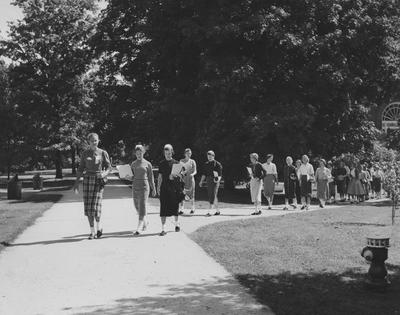 Registration and Freshman Week--group of freshman girls walking on campus; Susan Haselden is in the front, the next two girls are Margaret Fistrell and Susan Freed